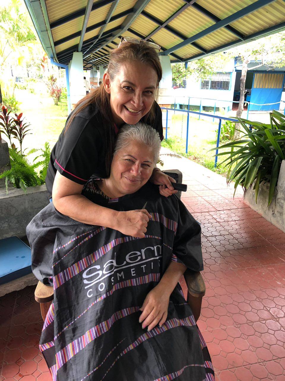 Una mujer dandole un corte de cabello a una adulta mayor